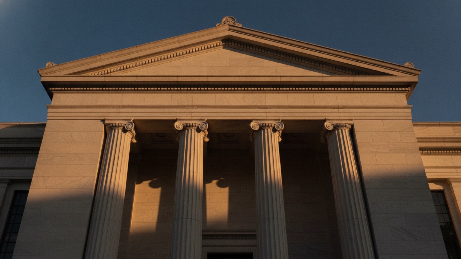 Stone columns of a classical bank building in late afternoon light